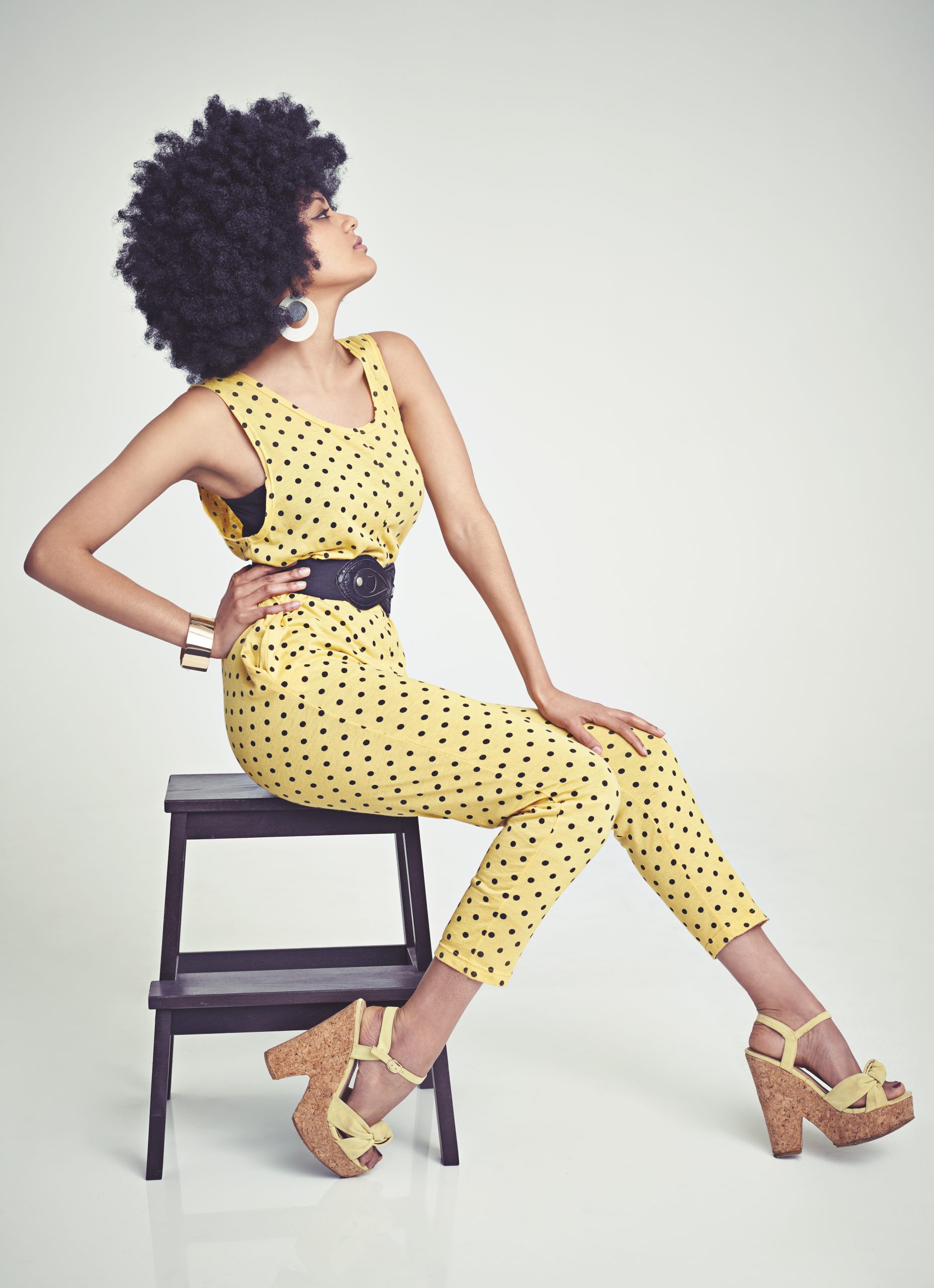 Shes got va va voom. A young woman wearing a 70s retro jumpsuit while in the studio