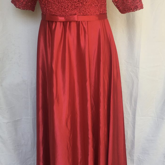 Elegant red lace and satin gown with a belted waist.