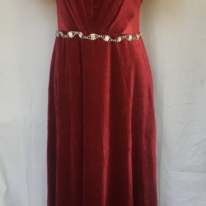 Elegant, floor-length red velvet dress with short sleeves and an embellished belt.